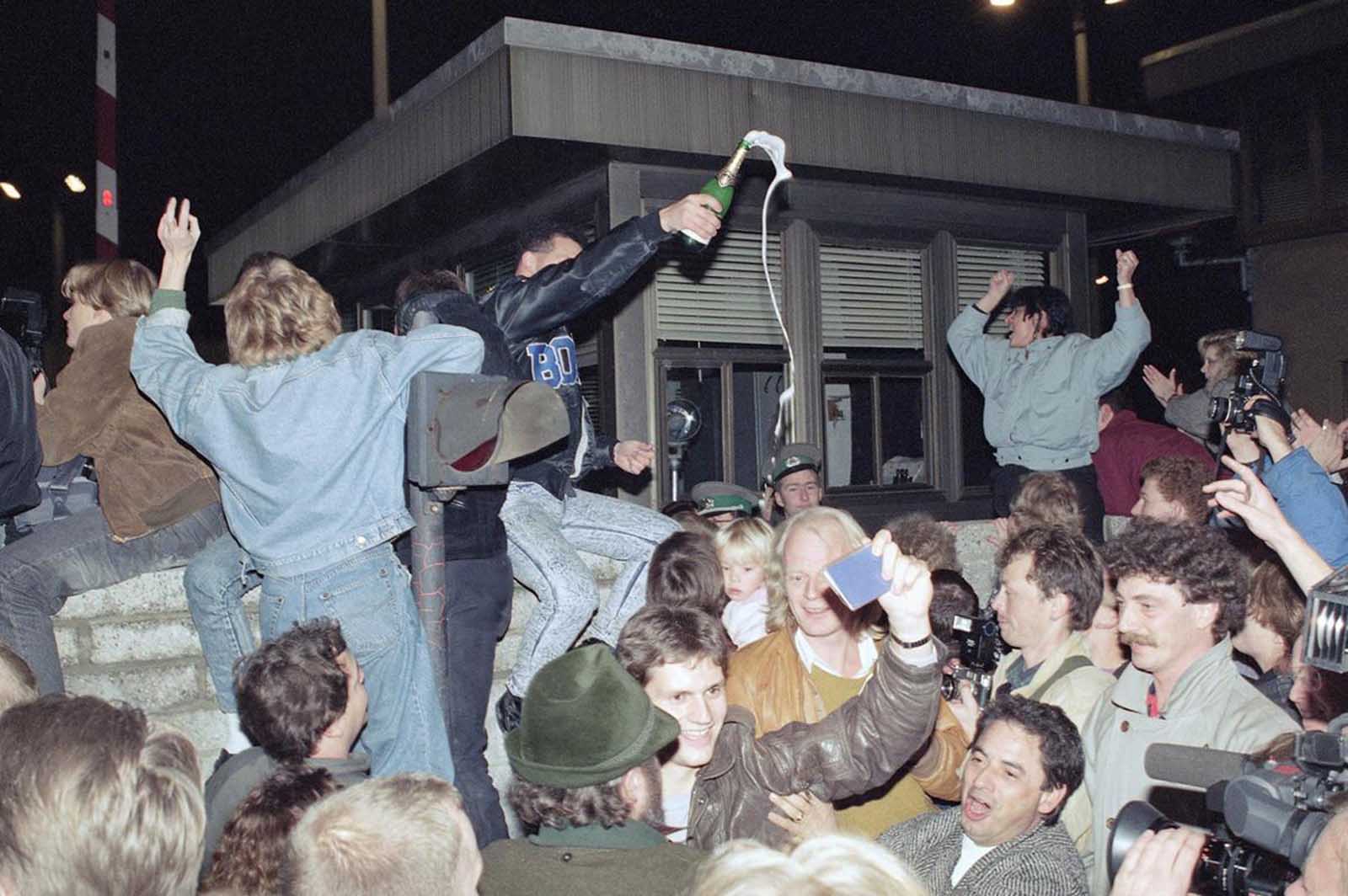 1989 жылы 10 қараша. Шығыс және Батыс берлиндіктер Шығыс Берлин аумағындағы бақылау станциясының алдындағы мерекеледі